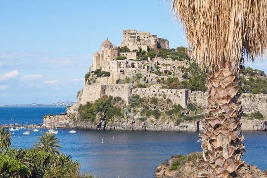 Ancient Aragonese Castle - Castello Aragonese - in Ischia Porto, Italy - The spectacular fortress with an exotic palm tree and blue ocean