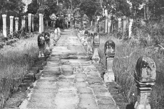 Banteay Srei temple gate and entrance - Pathway to the small temple near Angkor, still overgrown under Khmer Rouge control and landmined beside the pathways - black & white vintage low resolution photo from March 1992