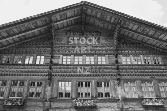 Beautifully decorated old Swiss chalet from 1693 - Saanen, Bernese Oberland, Switzerland - Black & white photo of the ancient building in Dorfstrasse, central Saanen 