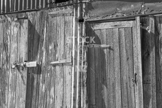 Black and white photo of old shed doors - Closeup of an antique wooden boat shed on Rangitoto Island near Auckland, NZ