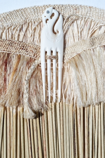 Closeup of a kahu pokowhiwhi with heru - Maori flax weaving - Shoulder cloak made of white muka fibre and pokinikini