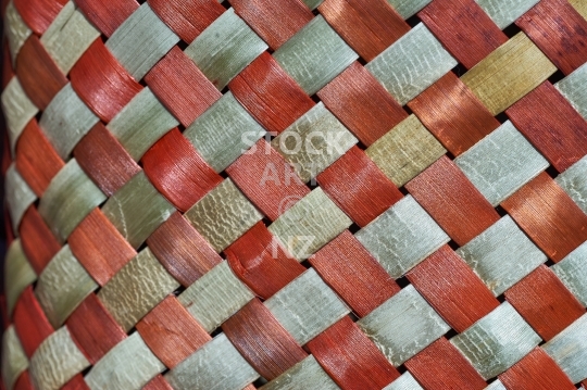 Closeup of New Zealand flax weaving dyed with burnt orange colours - Detailed view of a kete