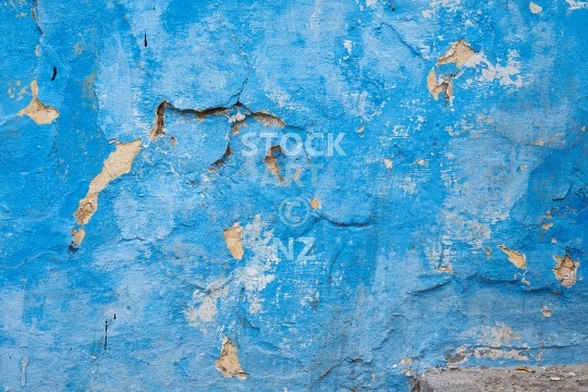 Crumbling turquoise blue house wall