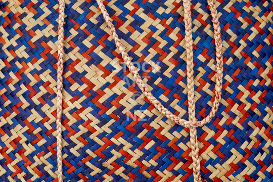 Flax weaving background - closeup of a kete with muka handles - Orange, blue and purple coloured woven flax bag, with property release