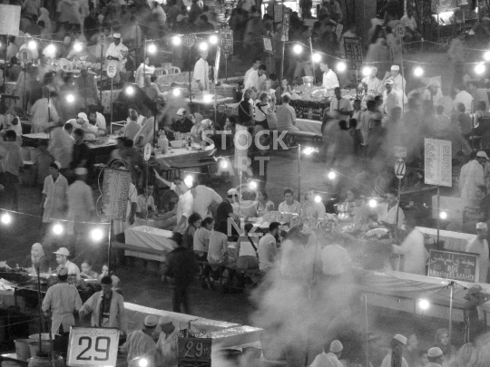 Jemaa el-Fnaa in Marrakesh at night - Closeup of the street food restaurant stalls and people at night – black & white lower resolution stock photo, ideal for web use
