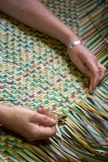 Maori flax weaving in progress - raranga harakeke - Closeup with weaver’s hands 