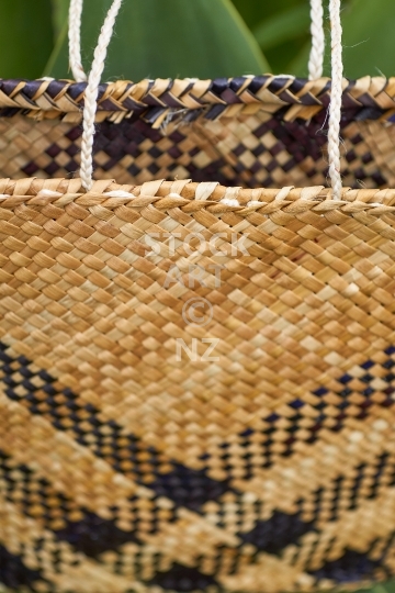 Maori kete with handles standing up - Flax weaving closeup of a black and white kete with taki tahi weaving pattern