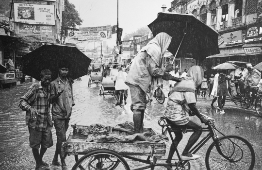 Monsoon flooding in Varanasi - Typical street scene with people and rickshaws battling the annual rain and flood waters in Benares - vintage low resolution black & white photo from 1994