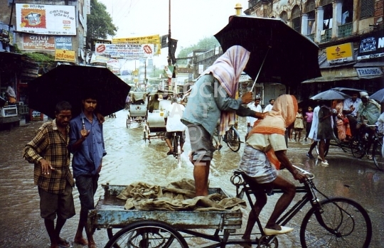 Monsoon flooding in Varanasi, India  - Vintage low resolution photo from 1994, flooded street in Benares with rickshaw and people in the rain