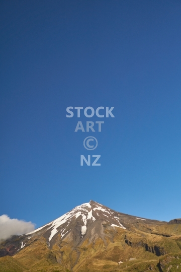 Mount Taranaki (Mount Egmont) in morning sunshine - Portrait with negative space blue sky background - New Zealand destinations