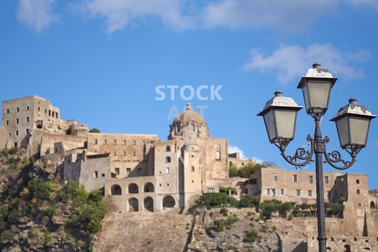 Old street lamp and the ancient Aragonese Castle in Ischia Porto, Italy - Castello Aragonese in the background
