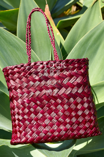 Small maroon colour flax kete - New Zealand flax weaving: handmade bag (photo with property release)