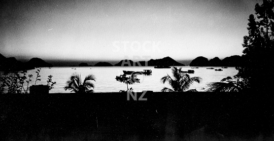 Sunset on Cat Ba Island - Absolute contrast at dusk, view of the idyllic Cat Ba town bay in Vietnam with fishing boats - old vintage black & white low resolution photo from 1994