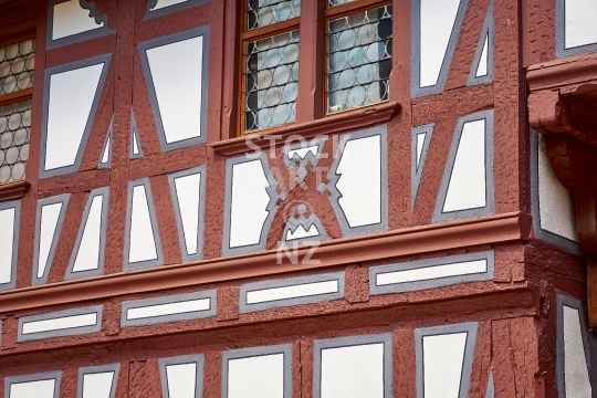 Typical medieval timber framed house in the old city centre of Basel, Switzerland - Closeup with crown glass windows