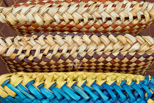 Underside of three straight flax kete - Colourful flax weaving background