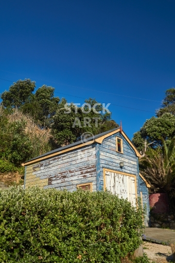Weathered old shed on Waiheke Island - Colourful typical old boat shed in Little Oneroa Bay, with deep blue sky above