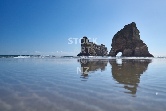 Wharariki Beach rocks - Golden Bay, South Island, New Zealand - The famous hole in the rock off this wild and remote West Coast beach, in a brooding atmosphere